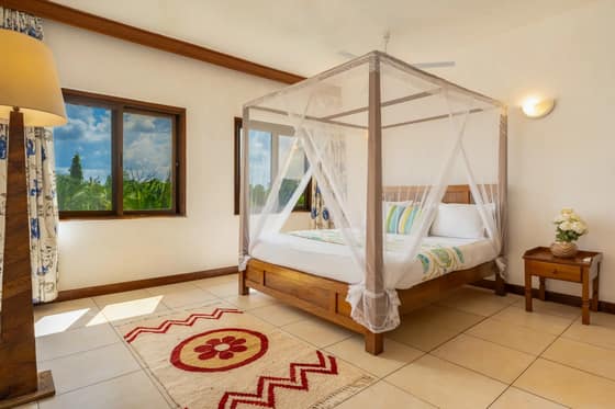 Tulia master bedroom with large windows and garden views